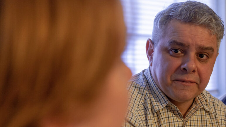 Mykola Vyshyvanyuk watches his wife as they tell the story of their decision to move from Ukraine to Alabama.