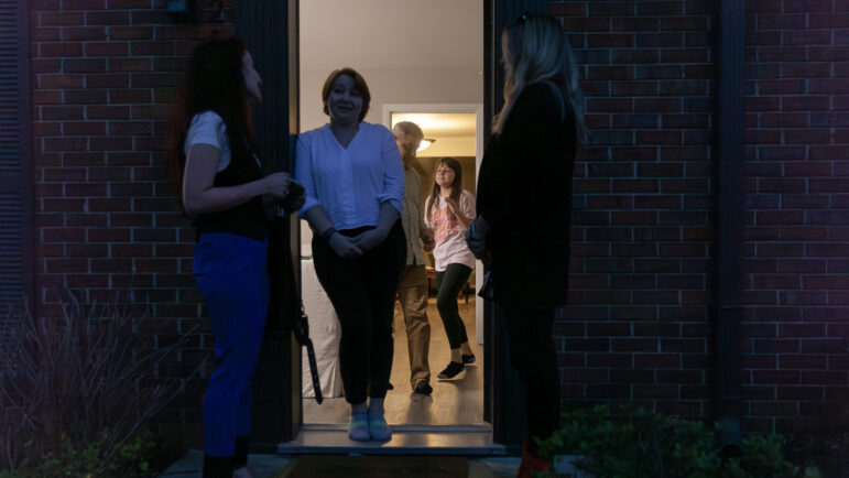 Irina Pritchett, Olena Vyshyvanyuk and Tatsiana Hall chat outside of the Vyshyvanyuk’s apartment as Mykola and his daughter Ioanna Vyshyvanyuk play in the background in Vestavia Hills, AL.