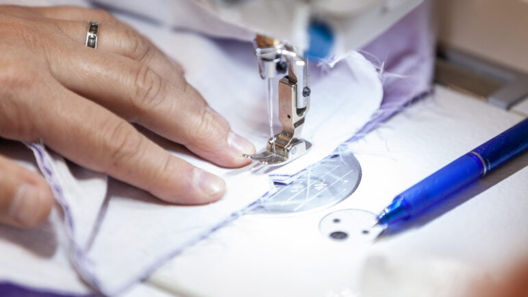 Mykola Vyshyvanyuk works on an alteration of a gown at Something You Couture in Vestavia Hills, AL.