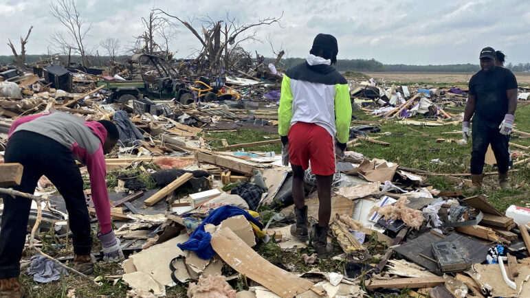 The grandchildren of the Pinkins family sort through the wreckage of their grandmother's home in Rolling Fork, Mississippi, for anything salvageable on March, 31, 2023.