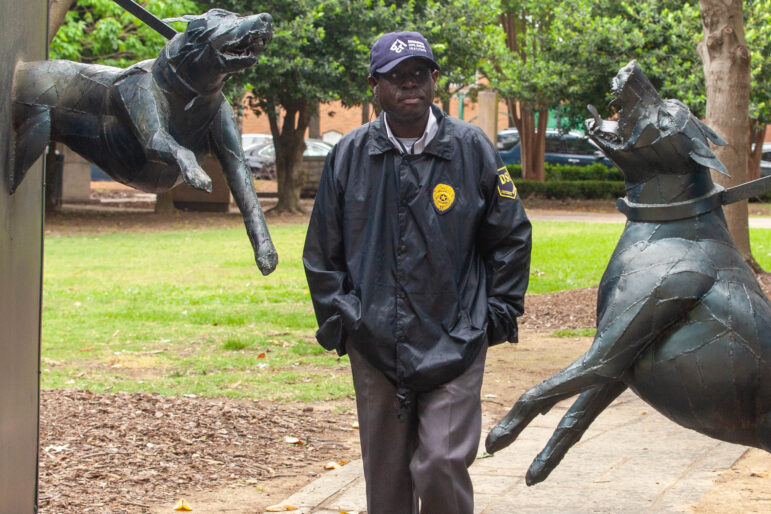 man walks through dog statue in kelly ingram park