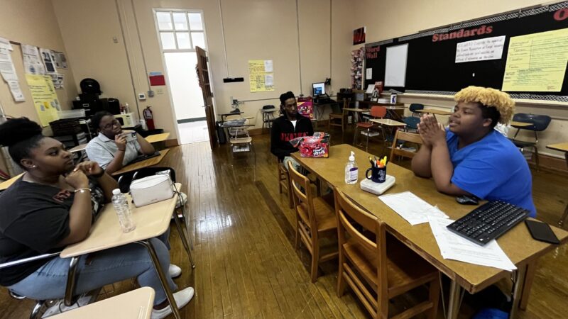 students sit in a class discusssing.