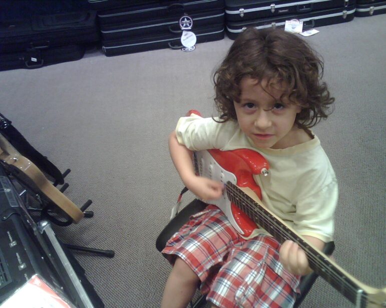 Little boy plays guitar