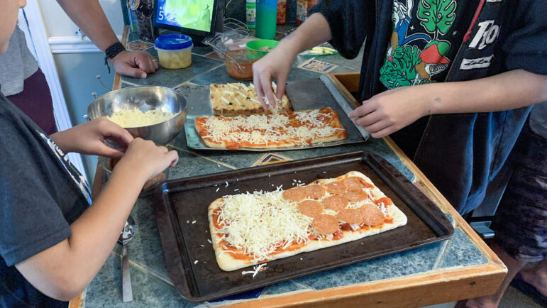 The Arenth family prepares pizzas for Friday night pizza night in Mandeville, Louisiana, on June 2, 2023.