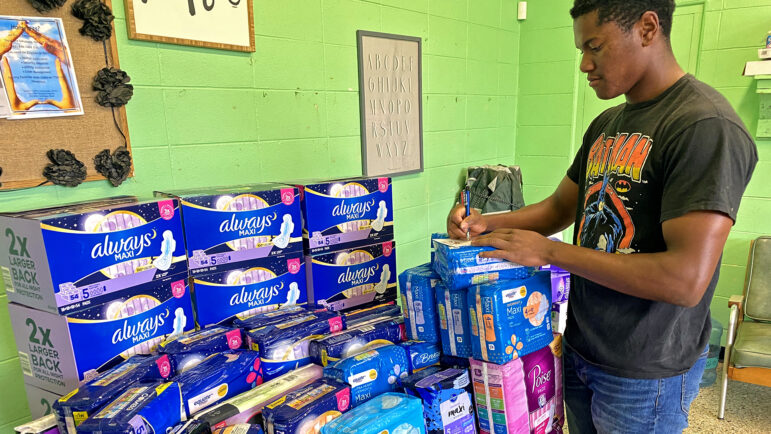 A volunteer at Diaper Bank of the Delta counts a donation of menstrual pads.