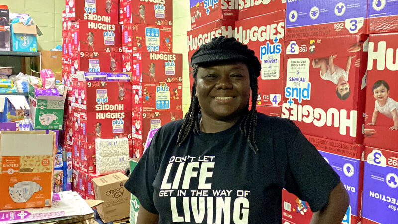 Chelesa Presley stands in front of boxes of diapers that were donated to Diaper Bank of the Delta.