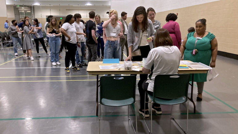 Participants stand in line to visit the courthouse station during a reentry simulation at UAB's recreation center, on March 24, 2023.