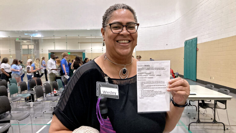 Trionne Carmichael holds up an assignment card for her role in the reentry simulation, March 24, 2023.