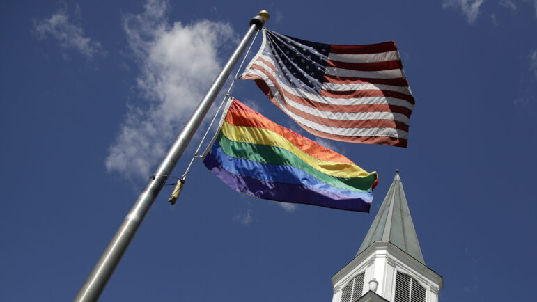 A gay Pride rainbow flag flies with the U.S. flag in front of the Asbury United Methodist Church in Prairie Village, Kan., on Friday, April 19, 2019. As of June 2023, more than 6,000 United Methodist congregations — a fifth of the U.S. total — have now received permission to leave the denomination amid a schism over theology and the role of LGBTQ people in the nation's second-largest Protestant denomination.