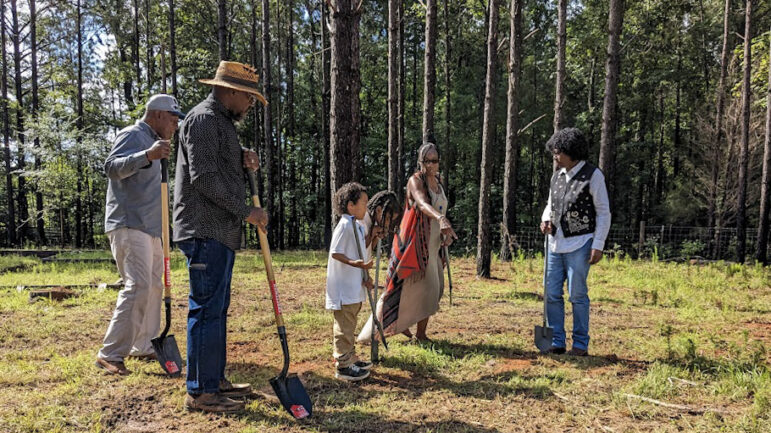 Teresa Ervin-Springs points to where to dig shovels as she stands next to her two mentors, her grandsons and husband Kevin Springs on June 19, 2023, in McCool, Mississippi.