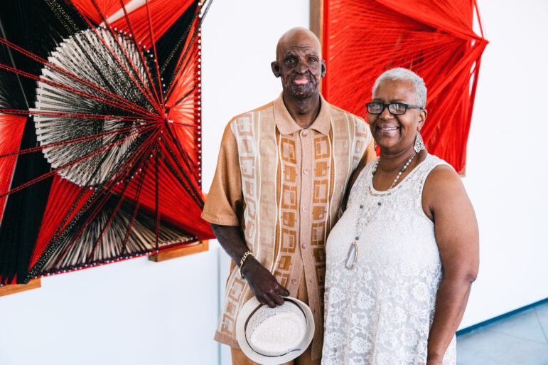 Delrico Gibson and Jackie Gibson pose in front of his artwork at UAB’s Abroms-Engel Institute for Visual Arts.