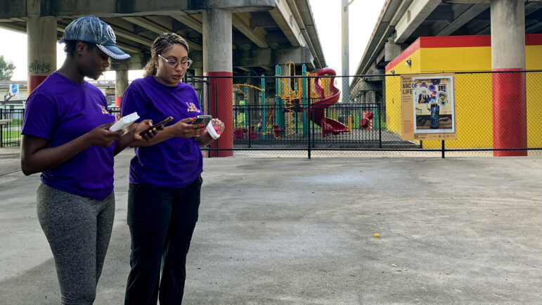 LSU School of Public Health graduate student researchers Jacquelynn Mornay (right) and Beatrice Duah (left) conduct an air monitoring test in front of Hunter’s Field Playground in New Orleans on July 18, 2023.