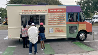 Attendees wait to receive free copies of banned books from the Banned Wagon outside of the [Un]Ban Book Festival at Baldwin & Co. in New Orleans on Oct. 5, 2023.
