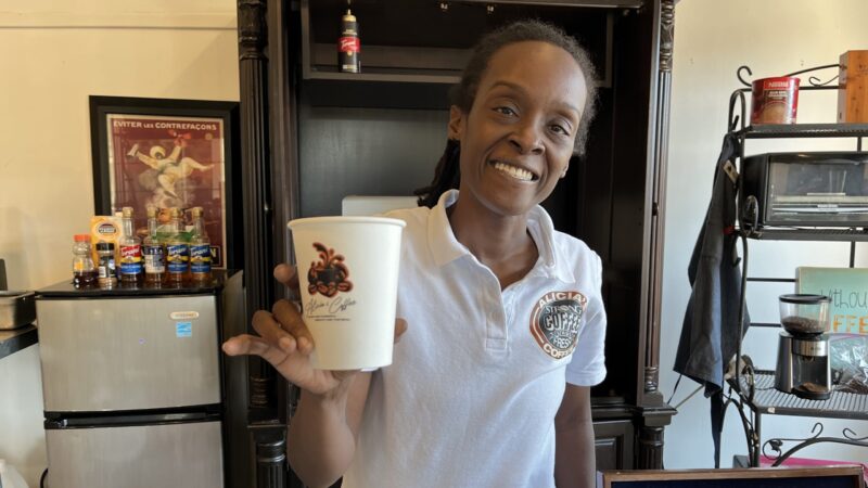 Alicia's Coffee owner Naimah Elmore holds a cup of coffee.