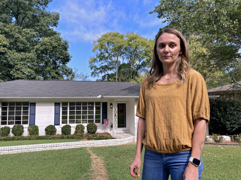 Claire Ahalt stands by a line of hay that cuts across her lawn in Birmingham, Alabama, Sept. 28, 2023.