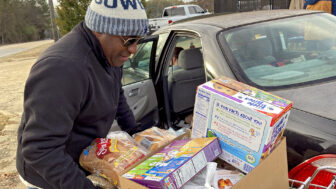 Volunteer Garrett Hereford loads boxes of food into cars at the St. Luke Food Pantry in Tupelo, Mississippi, on Nov. 30, 2023.