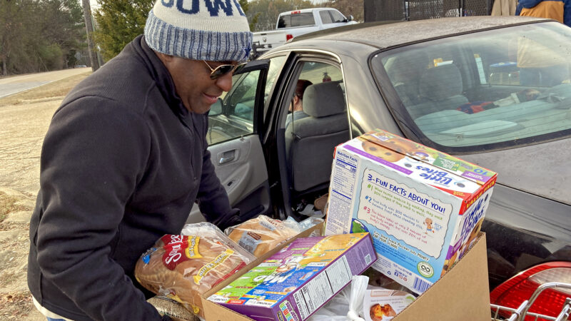 Volunteer Garrett Hereford loads boxes of food into cars at the St. Luke Food Pantry in Tupelo, Mississippi, on Nov. 30, 2023.