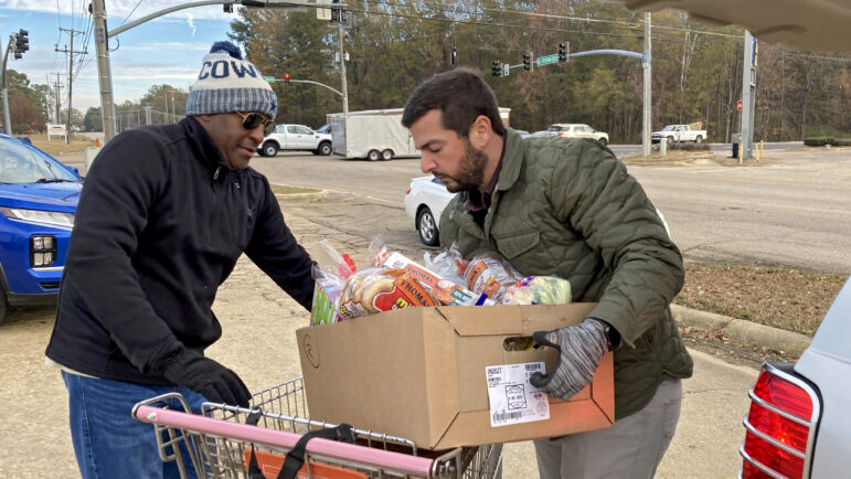 Volunteers deliver boxes of food to cars at the St. Luke Food Pantry in Tupelo, Mississippi, on Nov. 30, 2023.