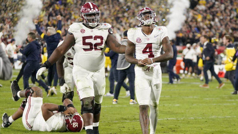 Alabama quarterback Jalen Milroe and offensive lineman Tyler Booker walk off the field after a loss to Michigan in the Rose Bowl.