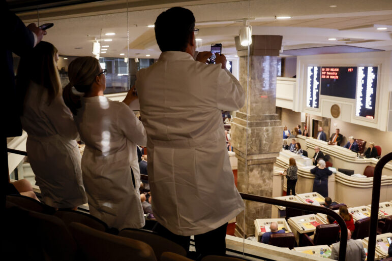 Doctors from the Alabama Fertility Clinic takes photos of the votes as the debate over the IVF fertility bill in the House Chambers is voted on.