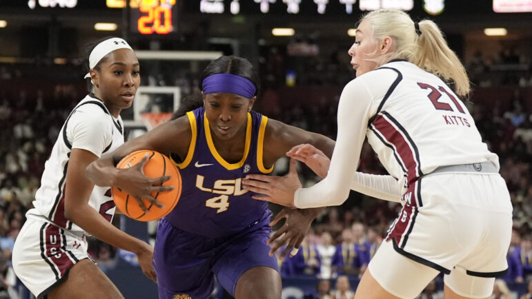 LSU guard Flau'jae Johnson drives to the basket between South Carolina guard Bree Hall and forward Chloe Kitts during the first half of an NCAA college basketball game at the Southeastern Conference women's tournament final Sunday, March 10, 2024, in Greenville, S.C.