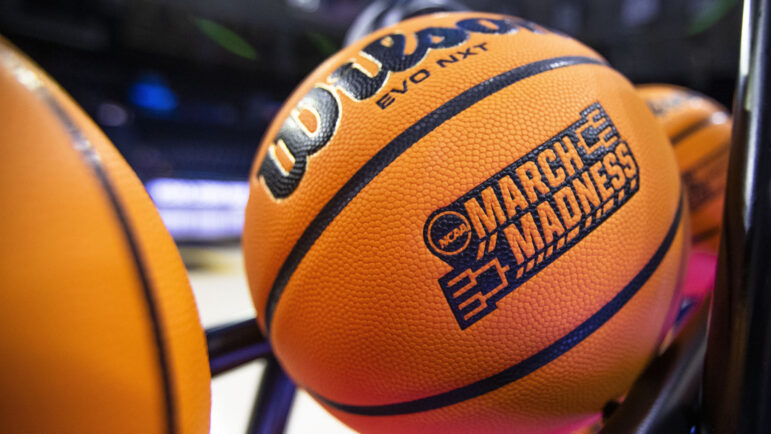 A basketball with a March Madness logo rests on a rack before a First Four game between Illinois and Mississippi State in the NCAA women's basketball tournament Wednesday, March 15, 2023, in South Bend, Ind.