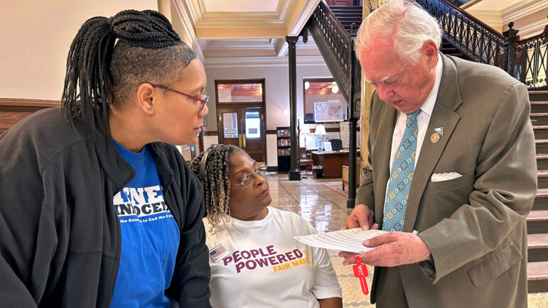 Exoneree Sabrina Butler-Smith (left) and an advocate from the League of Women Voters of Mississippi speak to Mississippi state Rep. John Read on March 5, 2024.