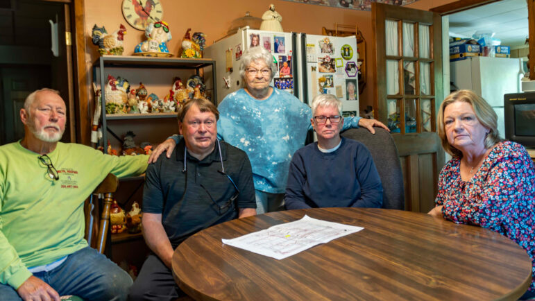 Clara Riley stands among her relatives and neighbors in her Oak Grove home.