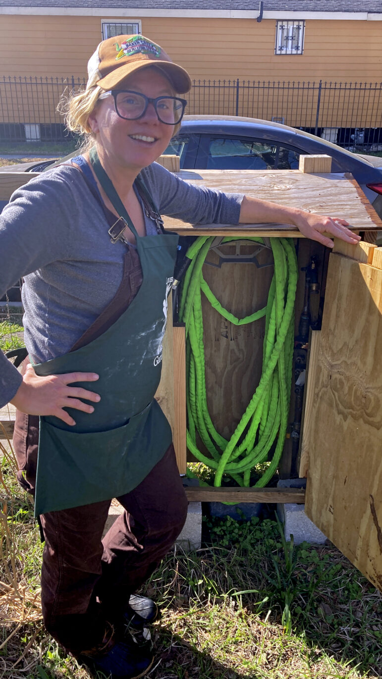Lissie Stewart shows off the hose and water connection for the Galvez Garden on Feb. 25, 2024.