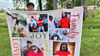 Family spokesperson Monica Fabre and relative Nadean Bailey hold a blanket printed with photos of Jerome Stevenson. Stevenson was in the custody of a Marksville, Louisiana, jail when he died following a violent incident.