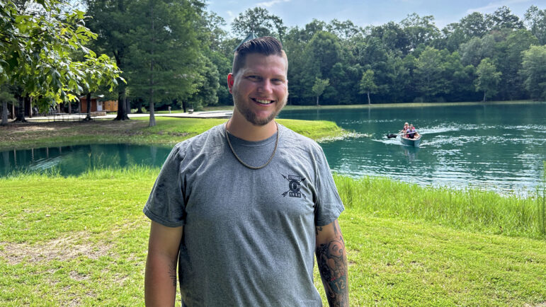 Cody Hanken stands in front of the lake at Camp Istrouma in Greenwell Springs, Louisiana, on June 12, 2024.