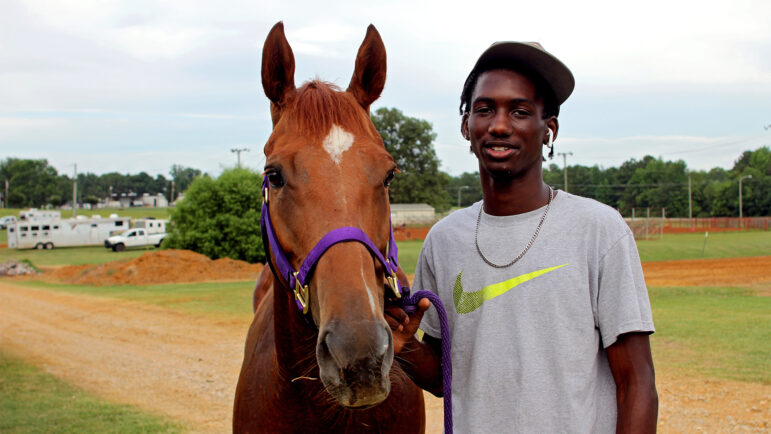 Jahvon Armstead poses with Hot Girl, a horse he rescued from the race tracks a year ago, before the Pontotoc Juneteenth Horse Show on June 19, 2024.