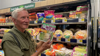 Richard Petcher picks out a fresh salad kit from the produce aisle of the Dollar General in Fruitdale, Alabama, on June 24, 2024.