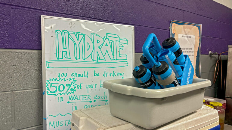 Water bottles sit in front of a whiteboard encouraging hydration in the A.H. Parker High School athletic trainer’s office in Birmingham, Alabama, on Aug. 22, 2024.