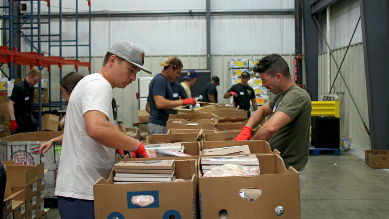 Volunteers from Maxwell Air Force Base sort frozen meats into smaller boxes at the Heart of Alabama food pantry warehouse in Montgomery, Alabama, on Aug 21, 2024.