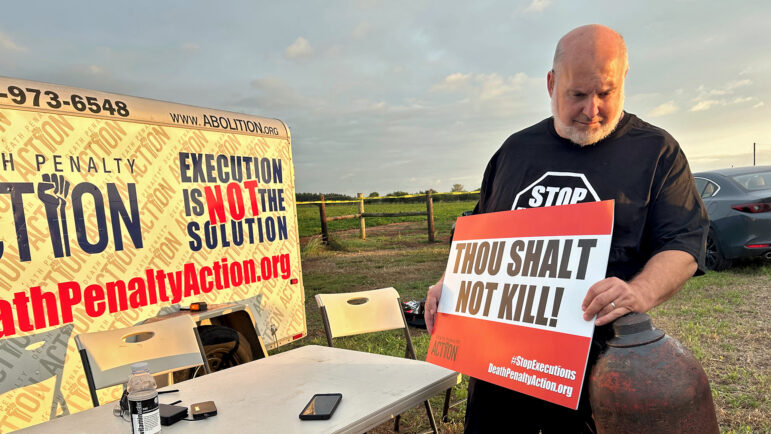 Death Penalty Action executive director Abraham Bonowitz holds a sign at a vigil in Atmore, Alabama, protesting the Sept. 26, 2024 execution of Alan Miller.