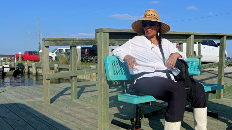 Rosina Philippe sits on a bench on the dock of Grand Bayou Indian Village in Louisiana on Sept. 20th, 2024.