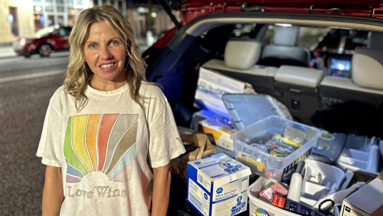 Suzanne Smith stands next to her SUV loaded with supplies for her “care packages,” including clean needles, bandages, antibiotic cream, clothes, water, tampons and sanitary wipes.