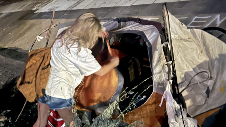 Suzanne Smith searches through a tent beneath a bridge in Birmingham, Alabama, looking for signs of Jeff, one of her people