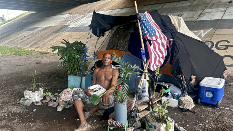 Julius, one of Suzanne Smith’s people, sits by his encampment with his plants in Birmingham, Alabama.