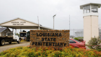 In this file photo, vehicles enter at the main security gate at the Louisiana State Penitentiary — the Angola Prison, the largest high-security prison in the country — in Angola, La., Aug. 5, 2008.