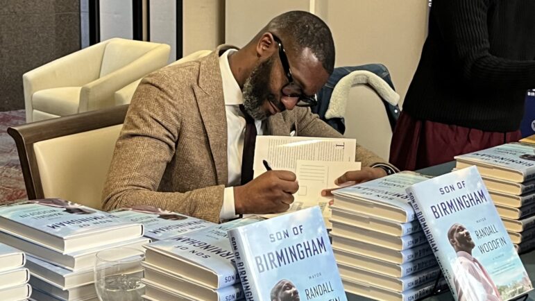 Birmingham Mayor Randall Woodfin signs copies of his new memoir following the Birmingham Kiwanis Club.