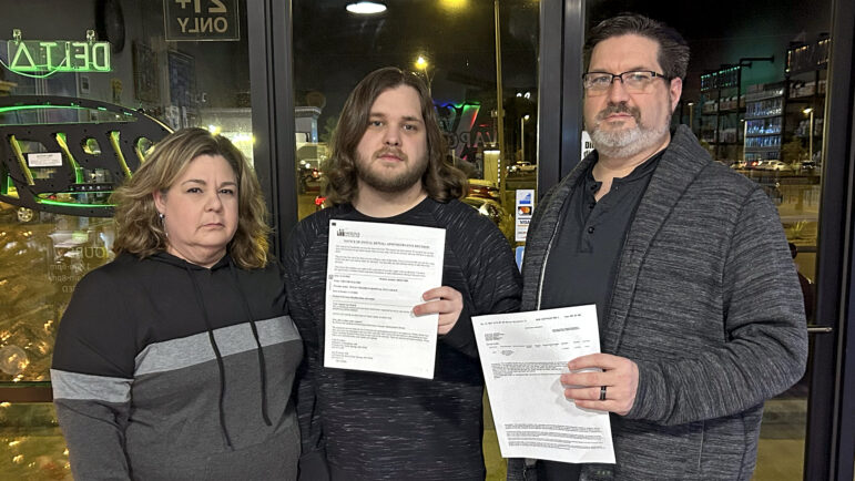 (left-right) Tracy, Trevor and Charles Malosh hold denial letters from Molina Healthcare in their family store in Ocean Springs, Mississippi, on Dec. 20, 2024.