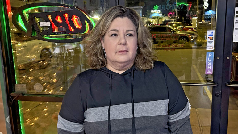 Tracy Malosh stands at the entrance of their family’s store in Ocean Springs, Mississippi, on Dec. 20, 2024.