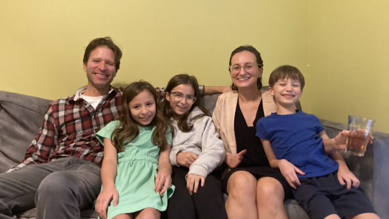 Josh and Diana Bernstein sit at their home with their three children.