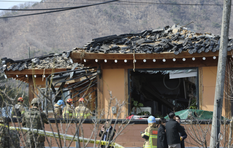 Rescue members work at a bomb accident site where a South Korean fighter jet accidentally dropped bombs Thursday on a civilian area during training, in Pocheon, South Korea.