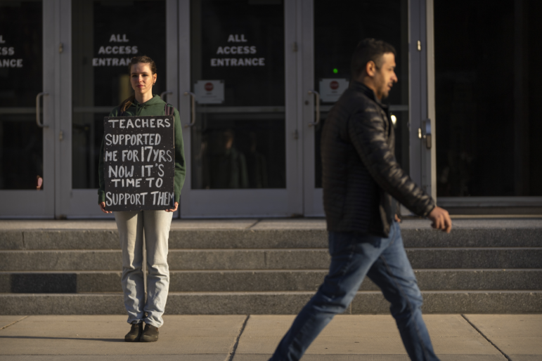 Chloe Kienzle of Arlington, Va., holds a sign as she stands outside the U.S. Department of Education, in Washington, D.C., on Wednesday – the day after the Trump administration announced widespread job cuts at the agency.