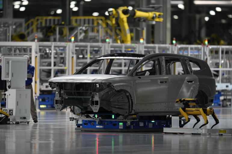 A Boston Dynamics robot "dog" inspects a vehicle body as part of quality control, as seen during a media tour at the Hyundai Motor Group Metaplant America in Ellabell, Ga., on March 26. During the grand opening ceremony for the plant, which actually produced its first vehicle in October, company executives and Georgia politicians did not emphasize — or even mention — that the plant produces electric vehicles.