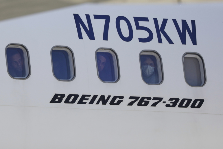 Venezuelan migrants deported from the United States peer through windows of an Eastern Airlines plane upon arriving at Simon Bolivar International Airport in Maiquetia, Venezuela, on Sunday, March 30, 2025.