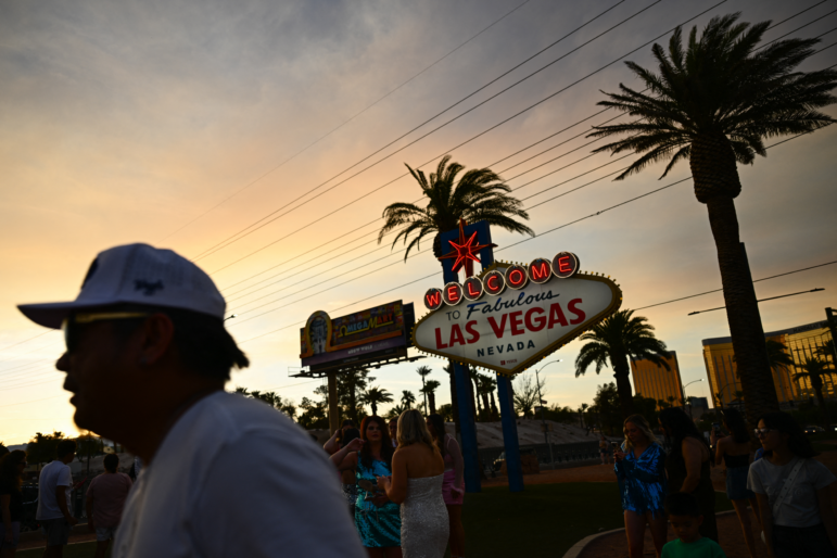 People take pictures with the Las Vegas sign in that city on July 29, 2023. Tourism industry leaders warn that recent actions by the Trump administration may be causing a drop in Canadians traveling to the U.S.